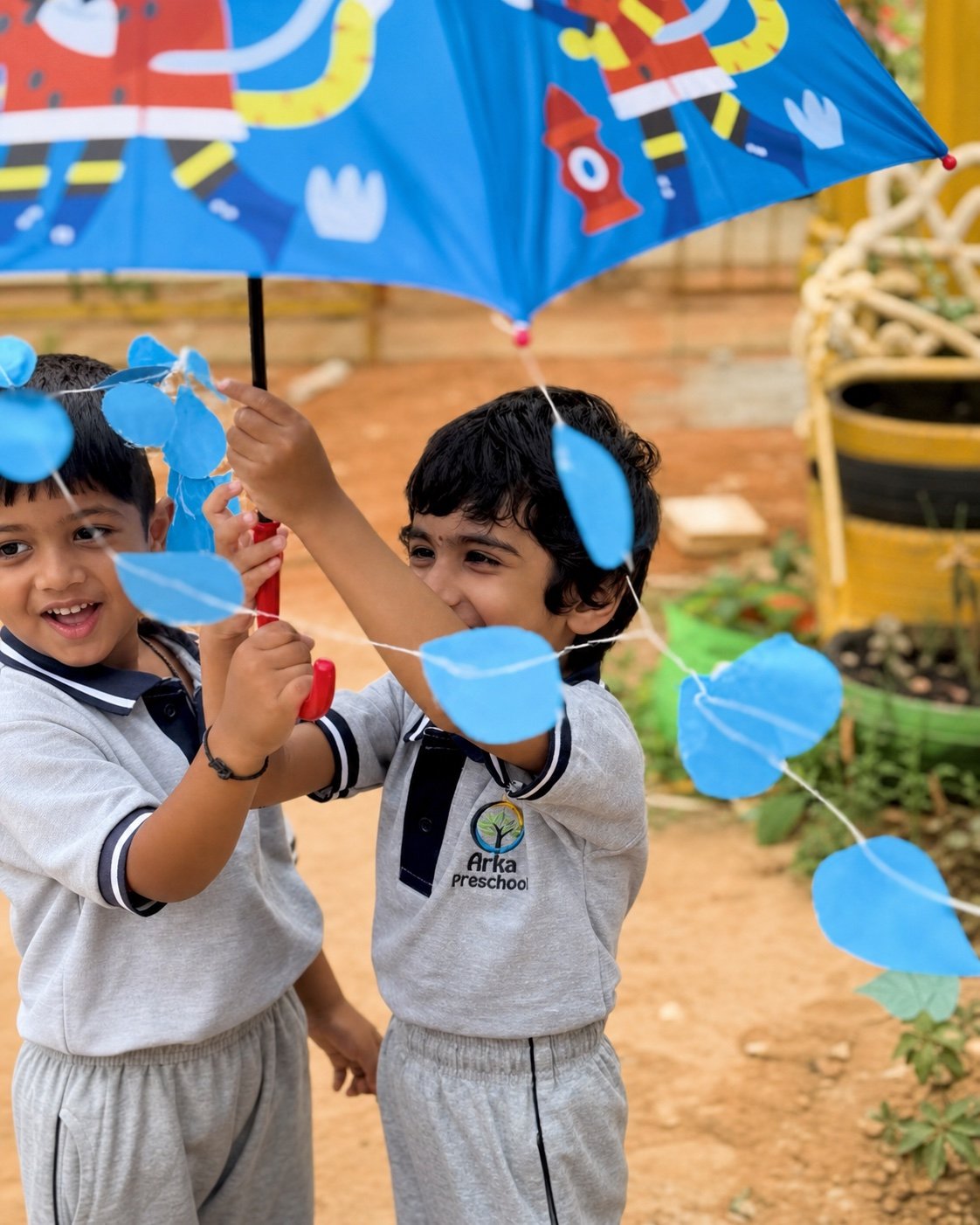 Children laughing together beneath an umbrella