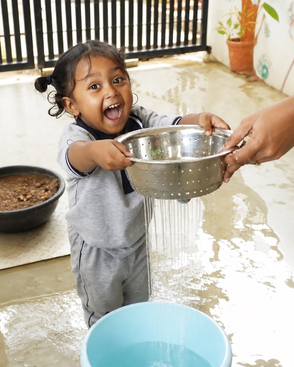 Arka child carrying water with delight