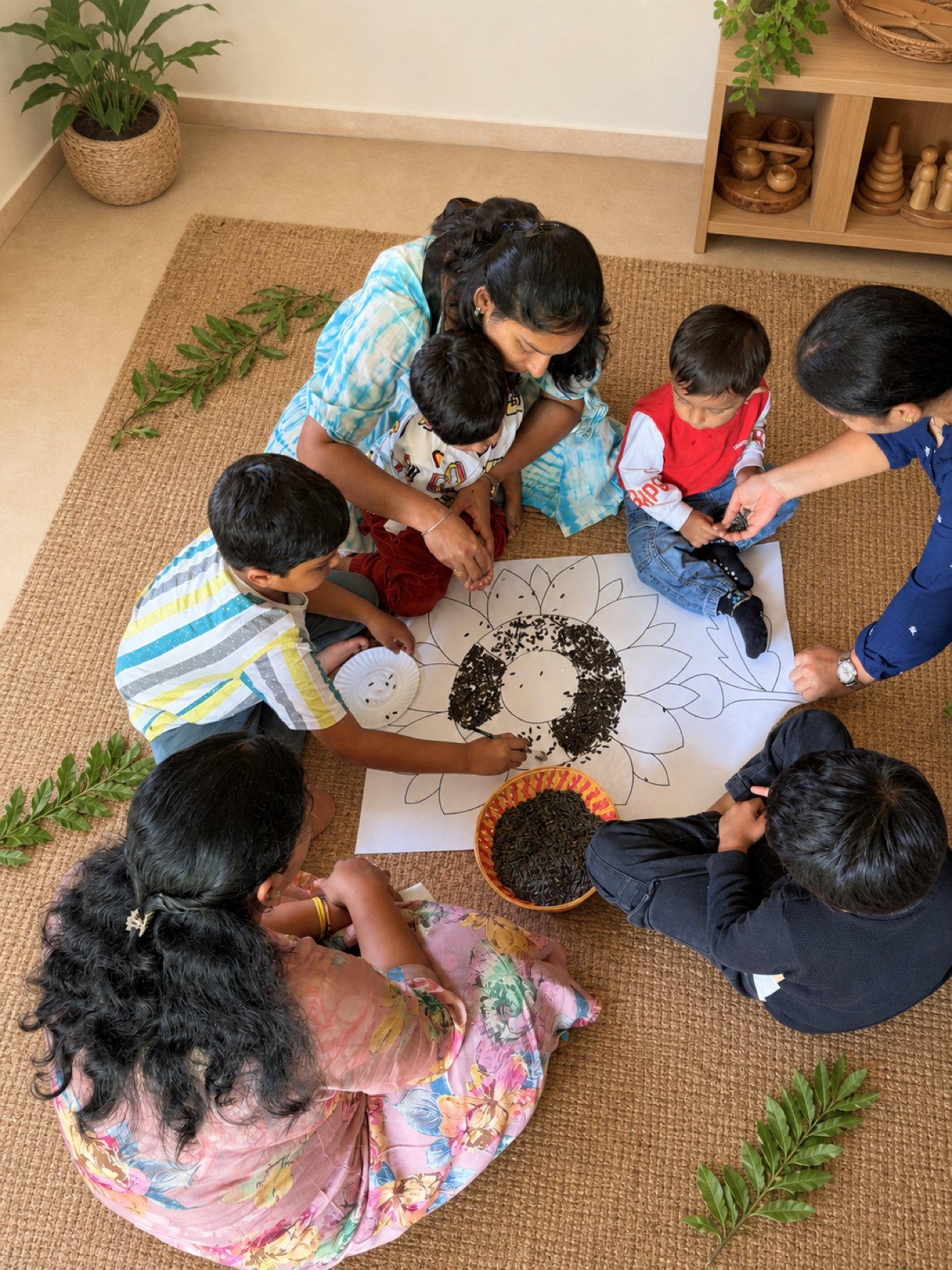 Children gathering around a soil and seed sunflower activity