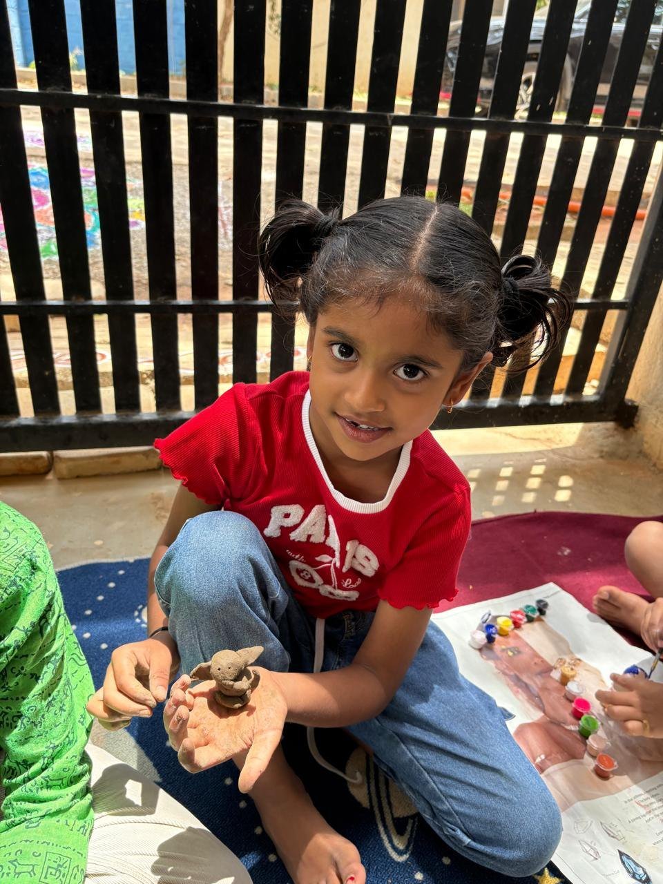 An Arka child showing her clay Ganesha creation