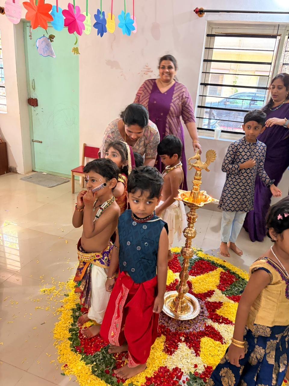 Children gathering around the flower display during the Krishna Janmashtami celebration