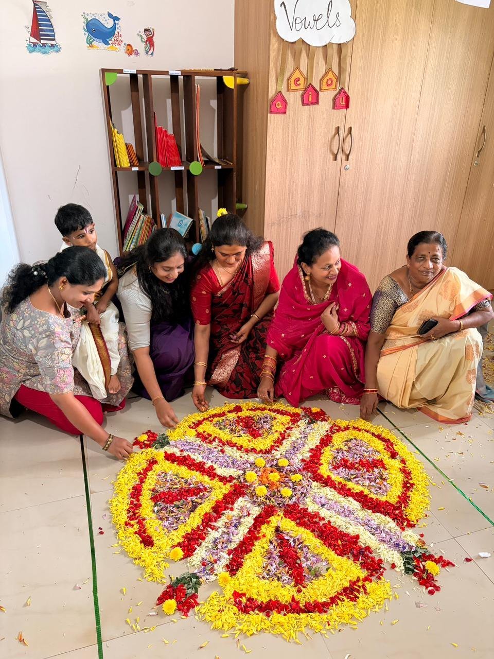 Families arranging flowers together in Arka's Onam pookalam