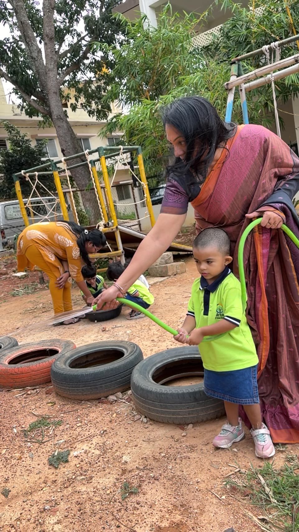 An educator guiding a child as they water plants